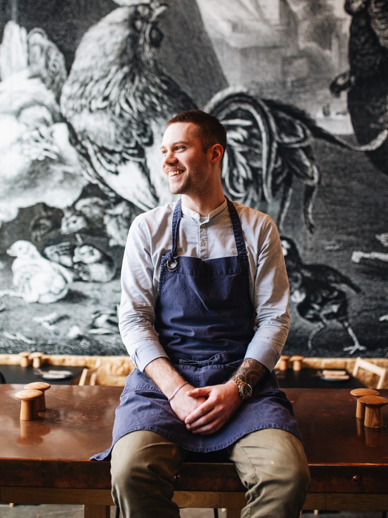 James Wilson sits on a table in the Farmyard Kitchen