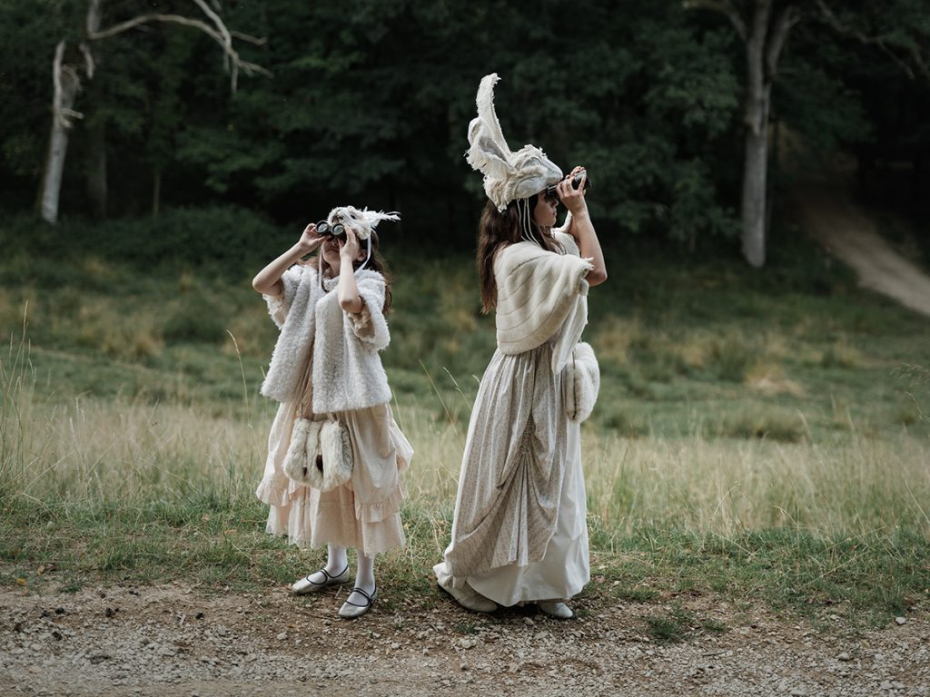 Two little girls with animal masks and binoculars